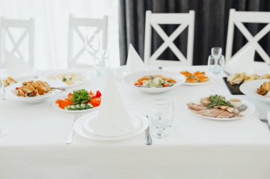 Sofra kurulumu çeşitli lezzetli yemekler ve akşam yemeği için rafine bir atmosfer içerir..