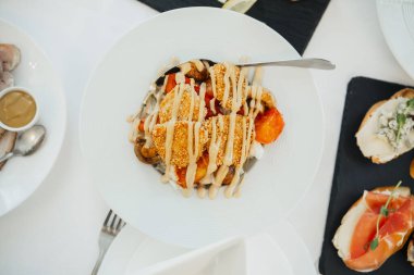 Renkli sebzeler ve lezzetli bir sos içeren güzel bir tabak..