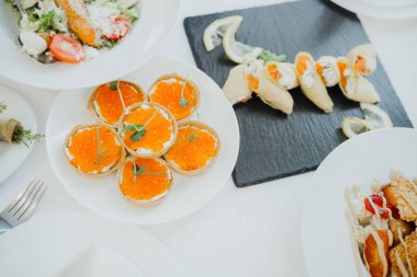 Yemek masasında taze malzemelerle sergilenen bir dizi gurme yemeği..