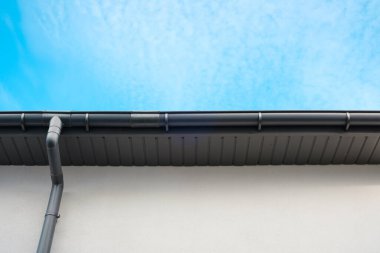 Modern bir binanın çatısı yukarıdaki parlak mavi gökyüzü ile çelişiyor..