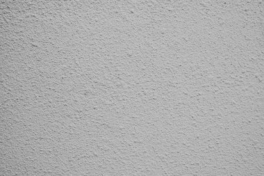 Gri duvar eşsiz bir doku sergiliyor, iç dekorasyon için derinlik ve ilgi ekliyor.