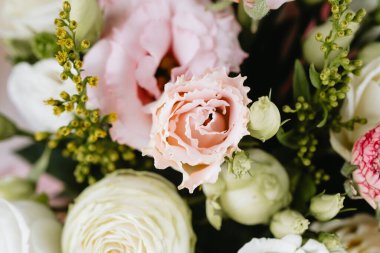 Yeşil aksanlı pembe ve beyaz çiçeklerden oluşan canlı bir çiçek sergisi..