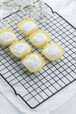 Tatlı ikramlar serinletici bir rafta narin çiçeklerin yanında..