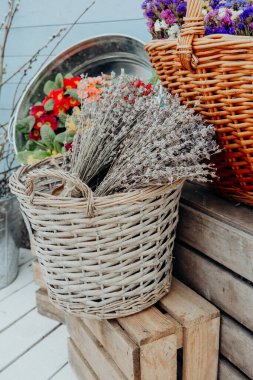 Lavanta ve canlı çiçekler açık havada tahta sandıkların üzerindeki sepetlerde sergilenir..