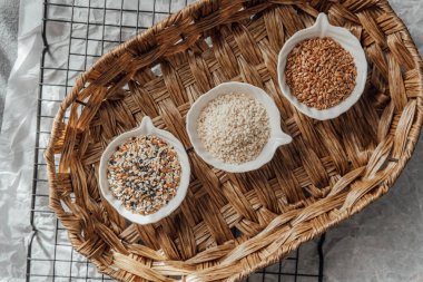 Örülmüş bir tepside kaselerde sergilenen farklı tohum türleri