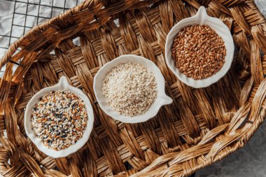 Örülmüş bir tepside kaselerde sergilenen farklı tohum türleri