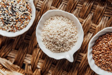 Örülmüş bir tepside kaselerde sergilenen farklı tohum türleri