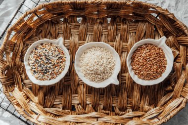 Örülmüş bir tepside kaselerde sergilenen farklı tohum türleri