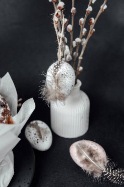 Tüylü Paskalya yumurtaları ve vazoda söğüt ağacı. Pastel pembe ve beyaz yumurta dekoru. Bayram kutlaması için arka planda.