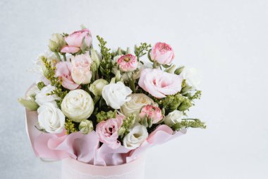 Yeşillik aksanlı pembe ve beyaz çiçeklerle güzel hazırlanmış bir buket..