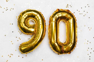90 şeklinde altın balonlar bir yüzeyde parlak konfetilerle düzenlenir..