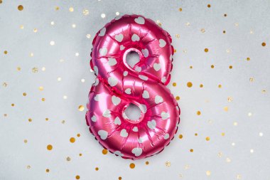 Sekiz numaralı pembe balon. Arka planda kalp izleri var..