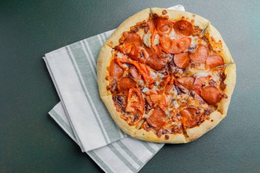 Katlanmış peçeteye konmuş acı biberli pizza, tadını çıkarmaya hazır..