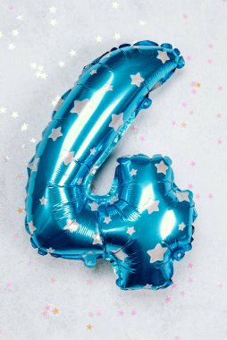 Gümüş yıldızlı dört numaralı parlak mavi balon kutlamayı süslüyor..