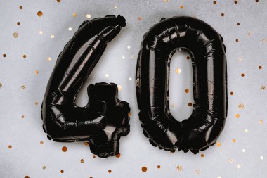 Altın konfetileriyle çevrili 40 numaralı şenlikli siyah balonlar..