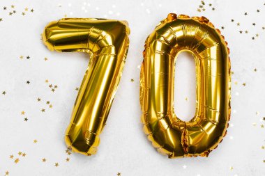 70 numaraya benzeyen altın balonlar yıldız konfetileriyle çevrilidir..