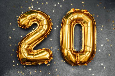 Yirmi numara şeklinde altın balonlar parlak yıldızlarla çevrilidir..