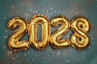 Parlak altın balonlar, 2028 yılında yıldızlarla çevrili renkli bir zemin oluşturur..