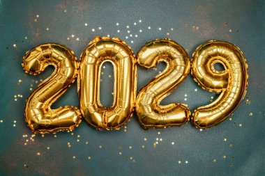 Balon sayıları 2029 yılını gösteriyor. Bir yüzeyde altın konfetilerle çevrili..
