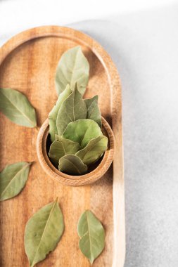 Yeşil defne yaprakları dikkatle ahşap bir tepside kaseyle sergilenir..