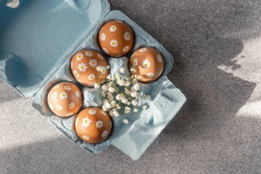 Çiçek desenli güzel boyanmış yumurtalar narin beyaz çiçeklerin arasına yerleştirilir..