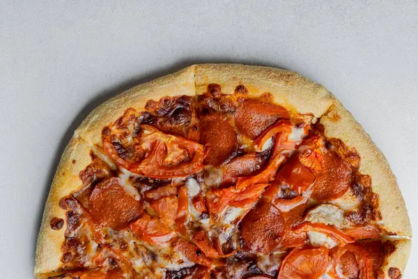 Altın hamurlu, erimiş peynirli, biberli ve taze domatesli lezzetli pizza..