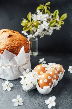 Güzel düzenlenmiş bir sergide ekmek, dekore edilmiş yumurtalar ve narin çiçekler yer alıyor..