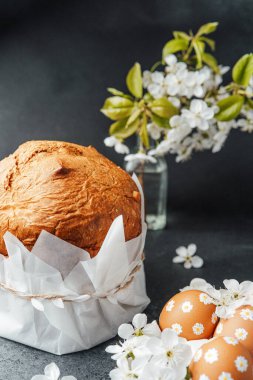 Çiçekler ve süslü yumurtalar arasında kağıda sarılmış bir somun ekmek..