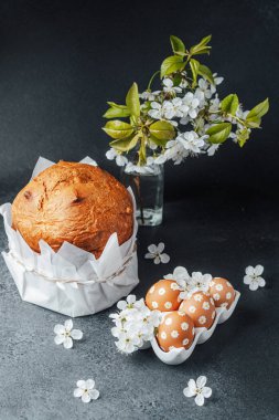 Paskalya için çiçek süslemeleri ve süslü yumurtalarla çevrili lezzetli tatlı ekmek..