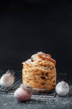 Dekoratif bir hamur işi bahar zamanı pastel renkli yumurtaların yanında serinletici bir rafta durur..