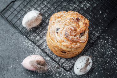 Taze pişmiş hamur işi, dekoratif yumurtaların yanında şekerle kaplanmış serinletici bir rafta duruyor..