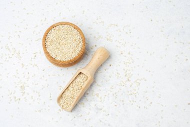 Küçük beyaz susam tohumları ahşap bir kaseye yerleştirilir ve kepçeyle çıkarılır..