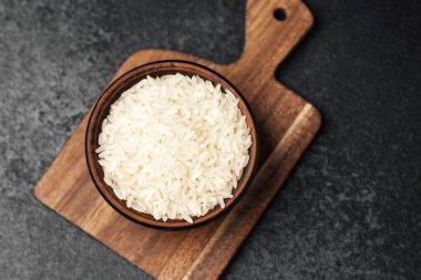 Beyaz pirinç kesme tahtasına yerleştirilmiş tahta bir kasede sergilenir..