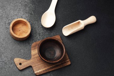 Çeşitli ahşap kaplar ve kaseler sanatsal olarak arka planda düzenlenir..