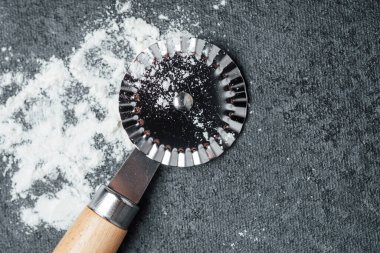 Hamur işleri sırasında un kaplı bir tezgahın üzerinde bir hamur işi duruyor..