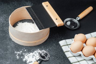 Un, yakınlarda yumurtalarla hazırlanıyor. Tezgahta fırınlama aletleri sergileniyor..