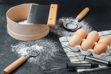 Taze yumurtalar pişirme aletleri ve un ile tezgahın üzerine serpiştirilir..