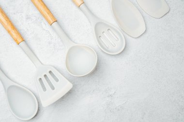 Farklı şekillerde silikon pişirme aletleri gri bir tezgahın üzerine yerleştirilmiş..