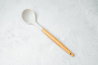 Tahta saplı kaşık, açık gri arkaplanda basit bir stile dayanır..