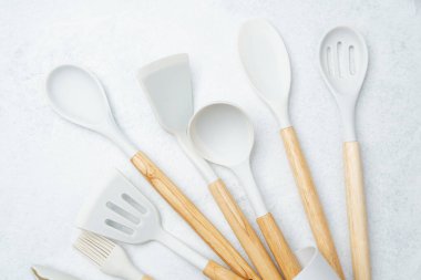 Çeşitli mutfak gereçleri hafif bir yüzey üzerinde yemek pişirmek için güzelce sergilenir..