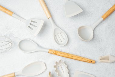 Spatulalar ve kaşıklar dahil çeşitli mutfak aletleri temiz ve modern bir estetik gösteriyor..