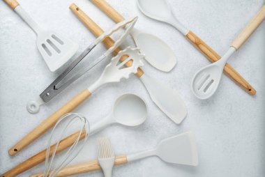 Spatulalar ve maşalar da dahil olmak üzere çeşitli mutfak aletleri yemek pişirmek için düzenli olarak düzenlenir..