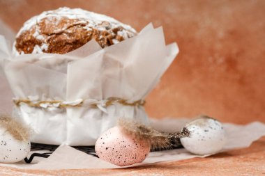 Geleneksel paskalya pastası, pudra şekeri ve parşömen kağıdında benekli yumurta. Bahar tatili için şenlikli gıda konsepti.