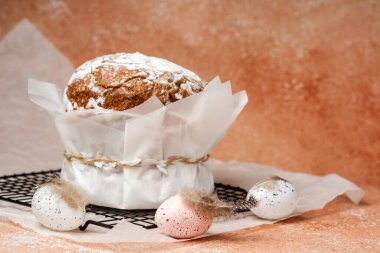 Geleneksel paskalya pastası, pudra şekeri ve parşömen kağıdında benekli yumurta. Bahar tatili için şenlikli gıda konsepti.