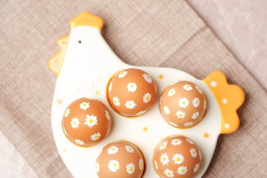 Beyaz papatya çiçekli Paskalya yumurtaları seramik tavuk tepsisinde.