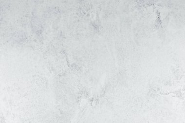 Açık gri beton bir yüzey yumuşak gölgelerde eşsiz doku ve desenler gösterir.