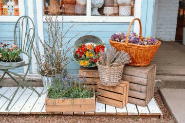 Parlak renkli çiçekler tuhaf bir dükkan girişinin yanındaki sepetlerde düzenlenir..
