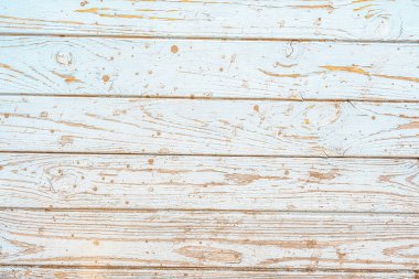 Yıpranmış ahşap kalaslar açık mavi bir renk ve düzensiz boya sıçramaları gösteriyor..