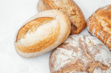 Çeşitli yuvarlak somunlar taze pişmiş, çeşitli dokular sergileniyor..