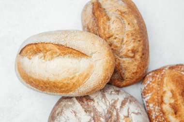 Hafif bir yüzeye yerleştirilmiş farklı pişmiş zanaatkar ekmekleri..